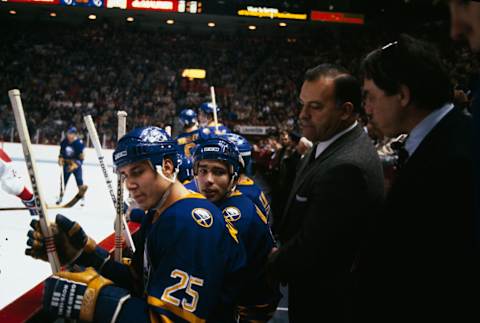 MONTREAL, CANADA- 1985: Head Coach Scotty Bowman of the Buffalo Sabres talks to Dave Andreychuk #25 of the Buffalo Sabres on the bench at the Montreal Forum in Montreal, Quebec, Canada. (Photo by Denis Brodeur/NHLI via Getty Images)