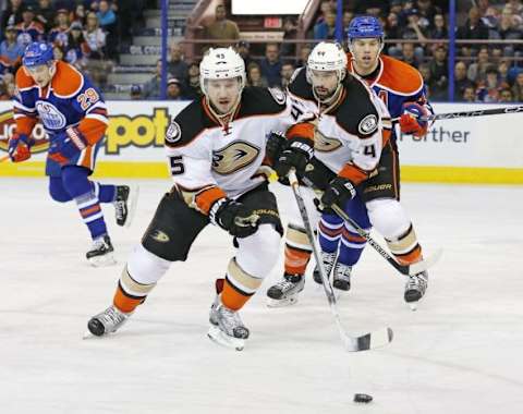 Feb 16, 2016; Edmonton, Alberta, CAN; Anaheim Ducks defensemen Korbinian Holzer (5) chases a loose puck in front of defensemen Cam Fowler (4) and Edmonton Oilers forward Taylor Hall (4) during the second period at Rexall Place. Mandatory Credit: Perry Nelson-USA TODAY Sports