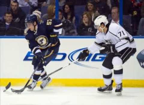 Mar 28, 2013; St. Louis, MO, USA; Los Angeles Kings center Jordan Nolan (71) attempts to knock the puck away from St. Louis Blues left wing David Perron (57) during the second period at the Scottrade Center. Mandatory Credit: Scott Rovak-USA TODAY Sports