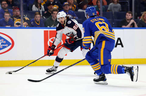 Sep 30, 2023; Buffalo, New York, USA; Columbus Blue Jackets left wing Kirill Marchenko (86) looks to make a pass as Buffalo Sabres defenseman Riley Stillman (61) defends during the first period at KeyBank Center. Mandatory Credit: Timothy T. Ludwig-USA TODAY Sports