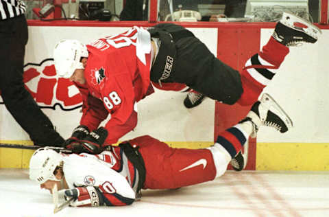 Team Canada’s Eric Lindros (top) falls on Gary Sutter of Team USA at the World Cup of Hockey in Philadelphia September 10, 1996. (Photo CARLO ALLEGRI/AFP via Getty Images)