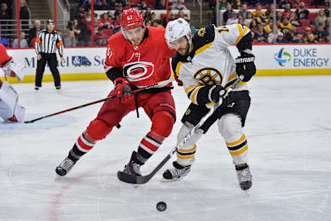 RALEIGH, NC – MARCH 13: Carolina Hurricanes Defenceman Trevor van Riemsdyk (57) and Boston Bruins Right Wing Brian Gionta (12) battle for a loose puck during a game between the Carolina Hurricanes and the Boston Bruins at the PNC Arena in Raleigh, NC on March 13, 2018. Boston defeated Carolina 6-4. (Photo by Greg Thompson/Icon Sportswire via Getty Images)