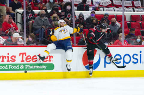 May 17, 2021; Raleigh, North Carolina, USA; Carolina Hurricanes left wing Jordan Martinook (48) checks Nashville Predators center Luke Kunin (11) during the first period in game one of the first round of the 2021 Stanley Cup Playoffs at PNC Arena. Mandatory Credit: James Guillory-USA TODAY Sports