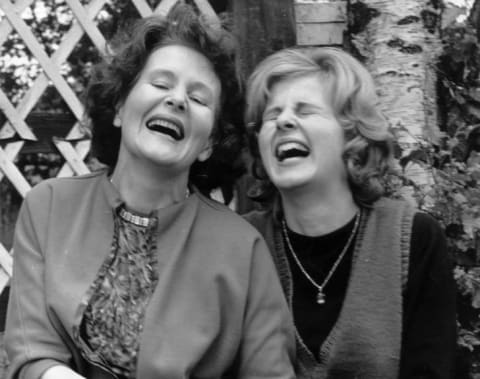 Two women laughing together.