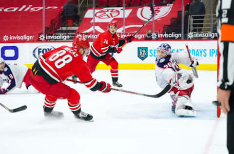 Mar 20, 2021; Raleigh, North Carolina, USA; Columbus Blue Jackets goaltender Elvis Merzlikins (90) makes a save on Carolina Hurricanes center Martin Necas (88) overtime shot at PNC Arena. Mandatory Credit: James Guillory-USA TODAY Sports