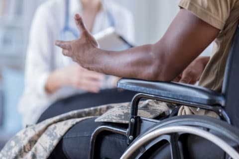 military man in wheelchair talking to doctor