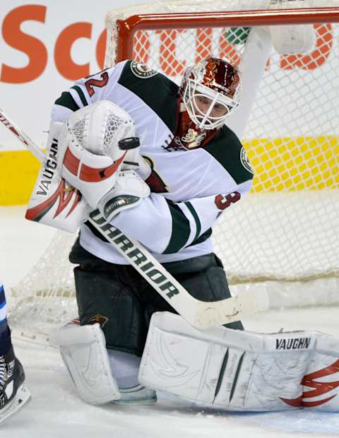 Dec 27, 2013; Winnipeg, Manitoba, CAN; Minnesota Wild goaltender Niklas Backstrom (32) makes a save against the Winnipeg Jets during the third period at MTS Centre. The Jets beat the Wild 6-4. Mandatory Credit: Fred Greenslade-USA TODAY Sports