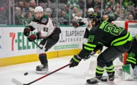 Jan 21, 2023; Dallas, Texas, USA; Arizona Coyotes left wing Michael Carcone (53) passes the puck over the stick of Dallas Stars left wing Mason Marchment (27) during the third period at the American Airlines Center. Mandatory Credit: Jerome Miron-USA TODAY Sports