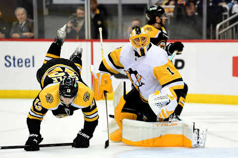 PITTSBURGH, PENNSYLVANIA – APRIL 21: Charlie Coyle #13 of the Boston Bruins falls on the ice against Casey DeSmith #1 of the Pittsburgh Penguins during the third period at PPG PAINTS Arena on April 21, 2022 in Pittsburgh, Pennsylvania. (Photo by Emilee Chinn/Getty Images)