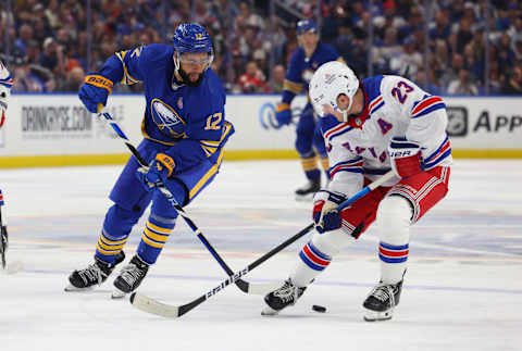 Oct 12, 2023; Buffalo, New York, USA; Buffalo Sabres left wing Jordan Greenway (12) and New York Rangers defenseman Adam Fox (23) go after a loose puck during the third period at KeyBank Center. Mandatory Credit: Timothy T. Ludwig-USA TODAY Sports