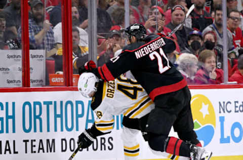 RALEIGH, NORTH CAROLINA – MAY 04: Nino Niederreiter #21 of the Carolina Hurricanes and Matt Grzelcyk #48 of the Boston Bruins battle for the puck during the second period of Game Two of the First Round of the 2022 Stanley Cup Playoffs at PNC Arena on May 04, 2022, in Raleigh, North Carolina. (Photo by Grant Halverson/Getty Images)