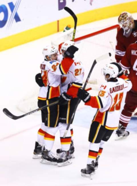 Nov 29, 2014; Glendale, AZ, USA; Calgary Flames left wing Jiri Hudler (24) celebrates a goal with center Sean Monahan (23) and left wing Johnny Gaudreau (13) against the Arizona Coyotes at Gila River Arena. Mandatory Credit: Mark J. Rebilas-USA TODAY Sports