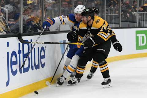 Jan 1, 2022; Boston, Massachusetts, USA; Boston Bruins defenseman Connor Clifton (75) checks Buffalo Sabres defenseman Rasmus Dahlin (26) into the boards during the second period at TD Garden. Mandatory Credit: Brian Fluharty-USA TODAY Sports