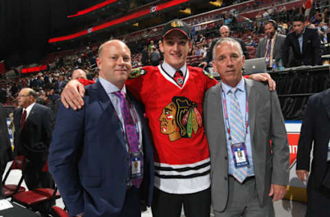 SUNRISE, FL – JUNE 27: Dennis Gilbert, 91st overall pick of the Chicago Blackhawks, stands on the draft floor with Stan Bowman and Mark Kelley (R) during the 2015 NHL Draft at BB