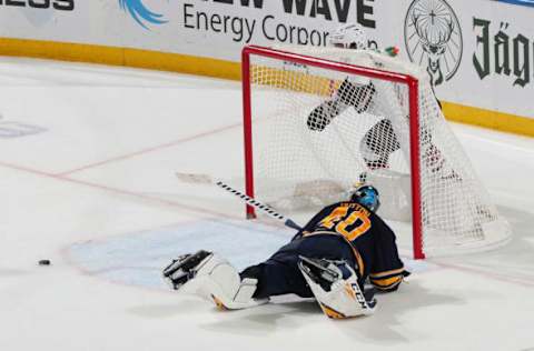 BUFFALO, NY – OCTOBER 28: Carter Hutton #40 of the Buffalo Sabres dives to sweep the puck away from Clayton Keller #9 of the Arizona Coyotes during overtime of an NHL game on October 28, 2019 at KeyBank Center in Buffalo, New York. Arizona won, 3-2. (Photo by Bill Wippert/NHLI via Getty Images)