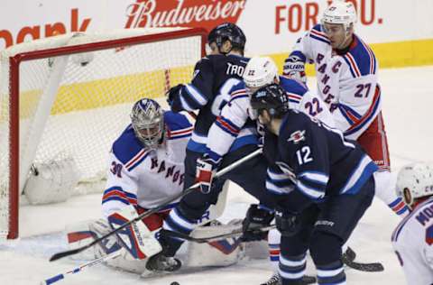 WINNIPEG, MB – DECEMBER 18: Henrik Lundqvist #30 of the New York Rangers keeps his eyes on the puck as he goes behind Jacob Trouba #8 of the Winnipeg Jets in first-period action in an NHL game at the MTS Centre on December 18, 2015 in Winnipeg, Manitoba, Canada. (Photo by Marianne Helm/Getty Images)