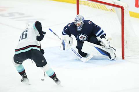 May 1, 2022; Winnipeg, Manitoba, CAN; Seattle Kraken forward Jared McCann (16) skates in on Winnipeg Jets goalie Eric Comrie (1) during the third period at Canada Life Centre. Mandatory Credit: Terrence Lee-USA TODAY Sports