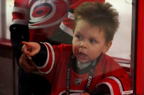 RALEIGH, NC – DECEMBER 28: A young fan of the Carolina Hurricanes sees his favorite team entering the ice before an NHL game against the Washington Capitals on December 28, 2019, at PNC Arena in Raleigh, North Carolina. (Photo by Gregg Forwerck/NHLI via Getty Images)