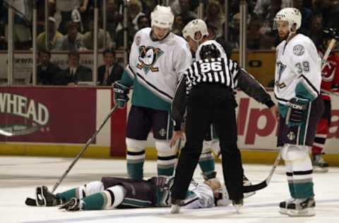 ANAHEIM, CA – JUNE 7: Teams watch over as Paul Kariya #9 of the Anaheim Mighty Ducks lies on the ice after being hit by Scott Stevens #4 of the New Jersey Devils during the second period in Game Six of the 2003 Stanley Cup Finals at the Arrowhead Pond of Anaheim on June 7, 2003, in Anaheim, California. The Ducks won 5-2. (Photo by Brian Bahr/Getty Images/NHLI)