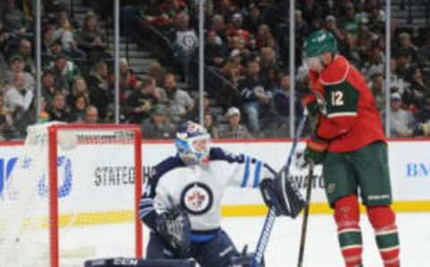 Oct 8, 2016; Saint Paul, MN, USA; Winnipeg Jets Goalie Michael Hutchinson (34) makes a save as Minnesota Wild forward Eric Staal (12) looks for a loose puck during the second period at Xcel Energy Center. Mandatory Credit: Marilyn Indahl-USA TODAY Sports