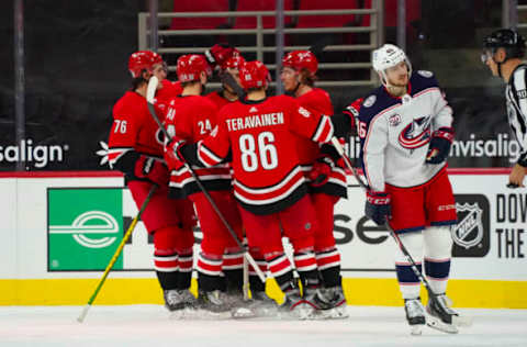 Feb 15, 2021; Raleigh, North Carolina, USA; Carolina Hurricanes left wing Brock McGinn (23) is congratulated by left wing Teuvo Teravainen (86) defenseman Jake Bean (24) right wing Sebastian Aho (20) and defenseman Brady Skjei (76) after his goal against the Columbus Blue Jackets during the third period at PNC Arena. Mandatory Credit: James Guillory-USA TODAY Sports