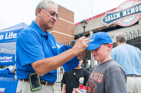 SALEM, VA – AUGUST 23: Former Boston Red Sox pitcher Mike Torrez signs a Mobil Super hat for Jacob Ballard, 12, outside Salem Memorial Ball Park before a Salem Red Sox game as part of Mobil Super “Go the Distance” Baseball Tour August 23, 2014, in Salem, Virginia. Torrez joined the Mobil Super team to meet fans and give away autographed baseballs and other prizes. (Photo by Steve Exum/Getty Images for Mobil Super)