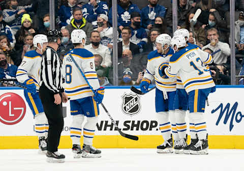 Mar 2, 2022; Toronto, Ontario, CAN; Buffalo Sabres right wing Kyle Okposo (21) celebrates after scoring a goal with defenseman Mark Pysyk (13) during the third period against the Toronto Maple Leafs at Scotiabank Arena. Mandatory Credit: Nick Turchiaro-USA TODAY Sports