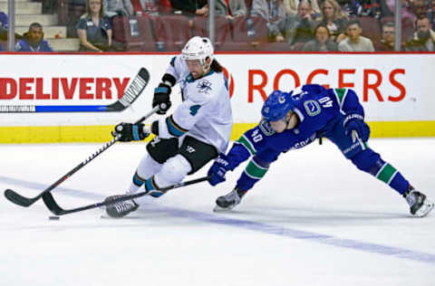 VANCOUVER, BC – APRIL 2: Elias Pettersson #40 of the Vancouver Canucks checks Brenden Dillon #4 of the San Jose Sharks during their NHL game at Rogers Arena April 2, 2019 in Vancouver, British Columbia, Canada. (Photo by Jeff Vinnick/NHLI via Getty Images)