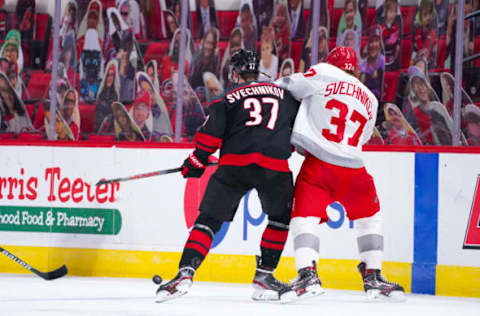 Mar 4, 2021; Raleigh, North Carolina, USA; Carolina Hurricanes right wing Andrei Svechnikov (37) and Detroit Red Wings left wing Evgeny Svechnikov (37) battle over the loose puck during the third period at PNC Arena. Mandatory Credit: James Guillory-USA TODAY Sports