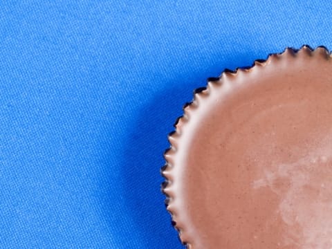 A partial shot of a peanut butter cup on a blue background.