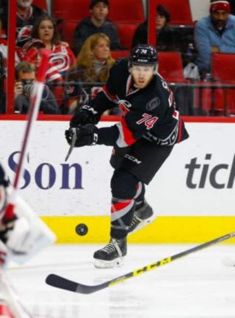 Dec 31, 2015; Raleigh, NC, USA; Carolina Hurricanes defensemen Jaccob Slavin (74) clears the puck against the Washington Capitals at PNC Arena. The Carolina Hurricanes defeated the Washington Capitals 4-2. Mandatory Credit: James Guillory-USA TODAY Sports