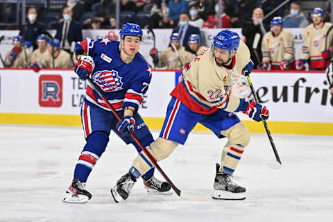 LAVAL, QC – APRIL 08: John Peterka #77 of the Rochester Americans and Alex Belzile #22 of the Laval Rocket skate against each other during the second period at Place Bell on April 8, 2022 in Laval, Canada. The Laval Rocket defeated the Rochester Americans 4-3 in overtime. (Photo by Minas Panagiotakis/Getty Images)