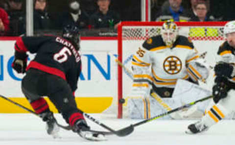 Jan 29, 2023; Raleigh, North Carolina, USA; Carolina Hurricanes defenseman Jalen Chatfield (5) takes shot at Boston Bruins goaltender Linus Ullmark (35) during the second period at PNC Arena. Mandatory Credit: James Guillory-USA TODAY Sports