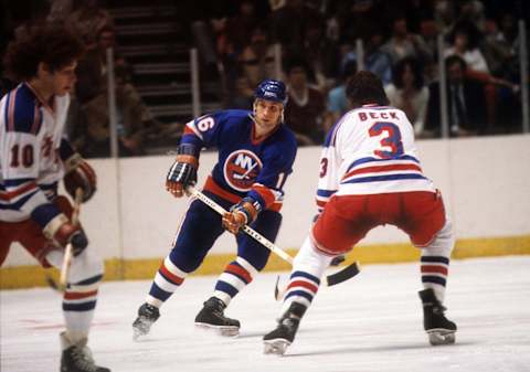 Mike McEwen #16 of the New York Islanders is defended by Barry Beck #3 of the New York Rangers