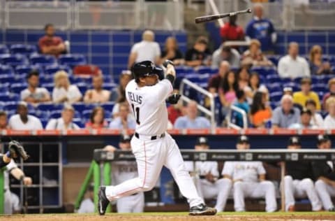 Aug 3, 2015; Miami, FL, USA; Miami Marlins catcher Tomas Telis (11) loses his bat during the ninth inning against the Miami Marlins at Marlins Park. The Mets won 12-1. Mandatory Credit: Steve Mitchell-USA TODAY Sports