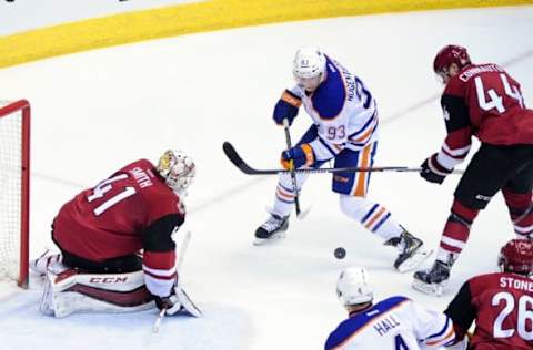 Mar 22, 2016; Glendale, AZ, USA; Edmonton Oilers center Ryan Nugent-Hopkins (93) tries to shoot the puck as Arizona Coyotes goalie Mike Smith (41), defenseman Kevin Connauton (44) and defenseman Michael Stone (26) defend during the first period at Gila River Arena. Mandatory Credit: Matt Kartozian-USA TODAY Sports