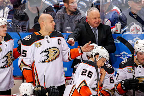 WINNIPEG, MB – JANUARY 13: Head Coach Randy Carlyle of the Anaheim Ducks tries to hold back Ryan Getzlaf #15 as he exchanges words with players on the Winnipeg Jets bench during a third-period stoppage in play at the Bell MTS Place on January 13, 2019, in Winnipeg, Manitoba, Canada. (Photo by Jonathan Kozub/NHLI via Getty Images)