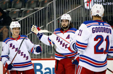 Mika Zibanejad #93 of the New York Rangers (C) celebrates, joined by Nils Lundkvist and Barclay Goodrow. (Photo by Bruce Bennett/Getty Images)