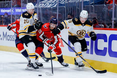 WASHINGTON, DC – MAY 15: Lars Eller #20 of the Washington Capitals chases the puck between Curti Lazar #20 and Mike Reilly #6 of the Boston Bruins during the second period during Game One of the First Round of the 2021 Stanley Cup Playoffs May 15, 2021, at Capital One Arena on May 15, 2021 in Washington, DC. (Photo by Tim Nwachukwu/Getty Images)