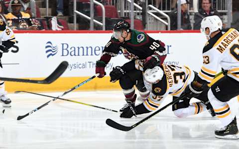 GLENDALE, ARIZONA – OCTOBER 05: Patrice Bergeron #37 of the Boston Bruins collides with Michael Grabner #40 of the Arizona Coyotes as they battle for the puck during the second period at Gila River Arena on October 05, 2019 in Glendale, Arizona. (Photo by Norm Hall/NHLI via Getty Images)