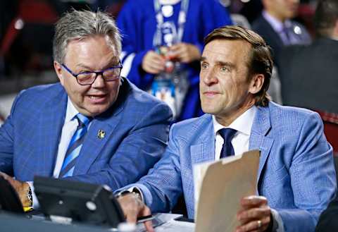 VANCOUVER, BRITISH COLUMBIA – JUNE 21: General manager Kelly McCrimmon (L) and president of hockey operations George McPhee of the Vegas Golden Knights look on from the team draft table during the first round of the 2019 NHL Draft at Rogers Arena on June 21, 2019 in Vancouver, Canada. (Photo by Jeff Vinnick/NHLI via Getty Images)