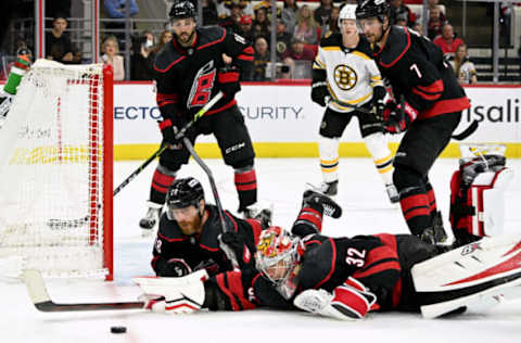 RALEIGH, NORTH CAROLINA – MAY 02: Ian Cole #28 and Antti Raanta #32 of the Carolina Hurricanes layout to block a shot by the Boston Bruins during the third period of Game One of the First Round of the 2022 Stanley Cup Playoffs at PNC Arena on May 02, 2022, in Raleigh, North Carolina. The Hurricanes won 5-1. (Photo by Grant Halverson/Getty Images)