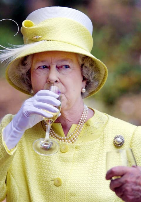 Queen Elizabeth II sipping a drink.