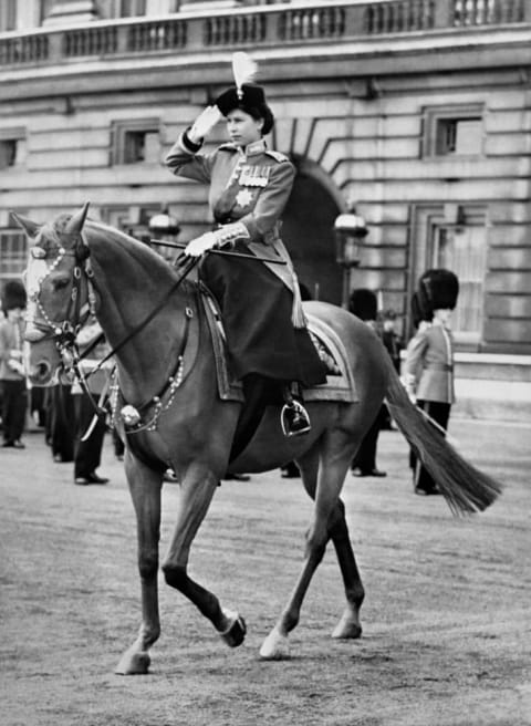 Britain's Queen Elizabeth II rides a horse side saddle and salutes during a Trooping of the Colour ceremony in London in 1952.