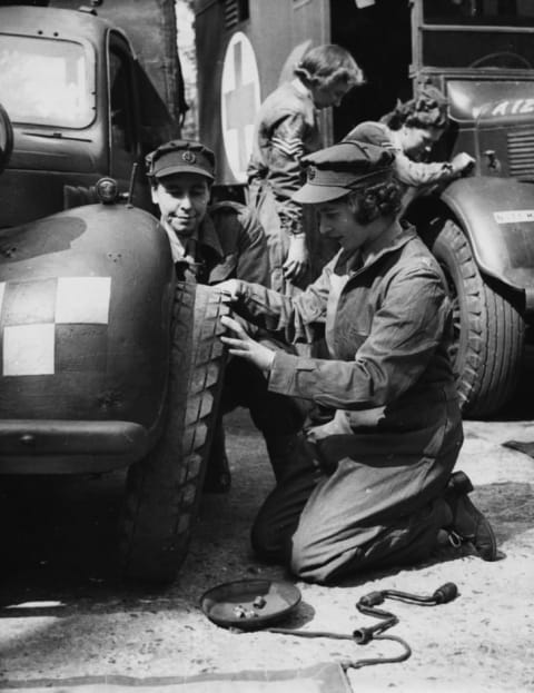 Princess Elizabeth changing the tire of a vehicle as she trains at as ATS Officer during World War II in April 1945.