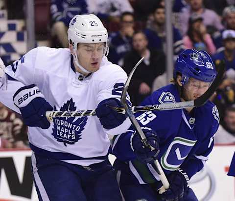 Dec 3, 2016; Vancouver, British Columbia, CAN; Toronto Maple Leafs forward James van Riemsdyk (25) battles for the puck against Vancouver Canucks defenseman Philip Larsen (63) during the second period at Rogers Arena. Mandatory Credit: Anne-Marie Sorvin-USA TODAY Sports