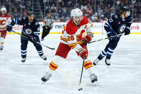 Apr 5, 2023; Winnipeg, Manitoba, CAN; Calgary Flames forward Elias Lindholm (28) skates into the Winnipeg Jets zone during the first period at Canada Life Centre. Mandatory Credit: Terrence Lee-USA TODAY Sports