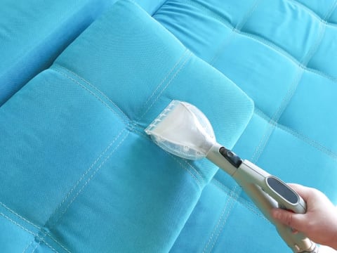 person cleaning a couch