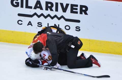 Dec 19, 2016; Glendale, AZ, USA; A trainer attends to Calgary Flames right wing Kris Versteeg (10) during the second period against the Arizona Coyotes at Gila River Arena. Mandatory Credit: Matt Kartozian-USA TODAY Sports