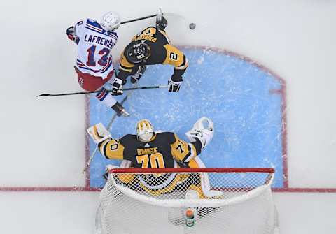 Alexis Lafrenière #13 of the New York Rangers goes for a loose puck in front of Louis Domingue #70 of the Pittsburgh Penguins. (Photo by Justin Berl/Getty Images)